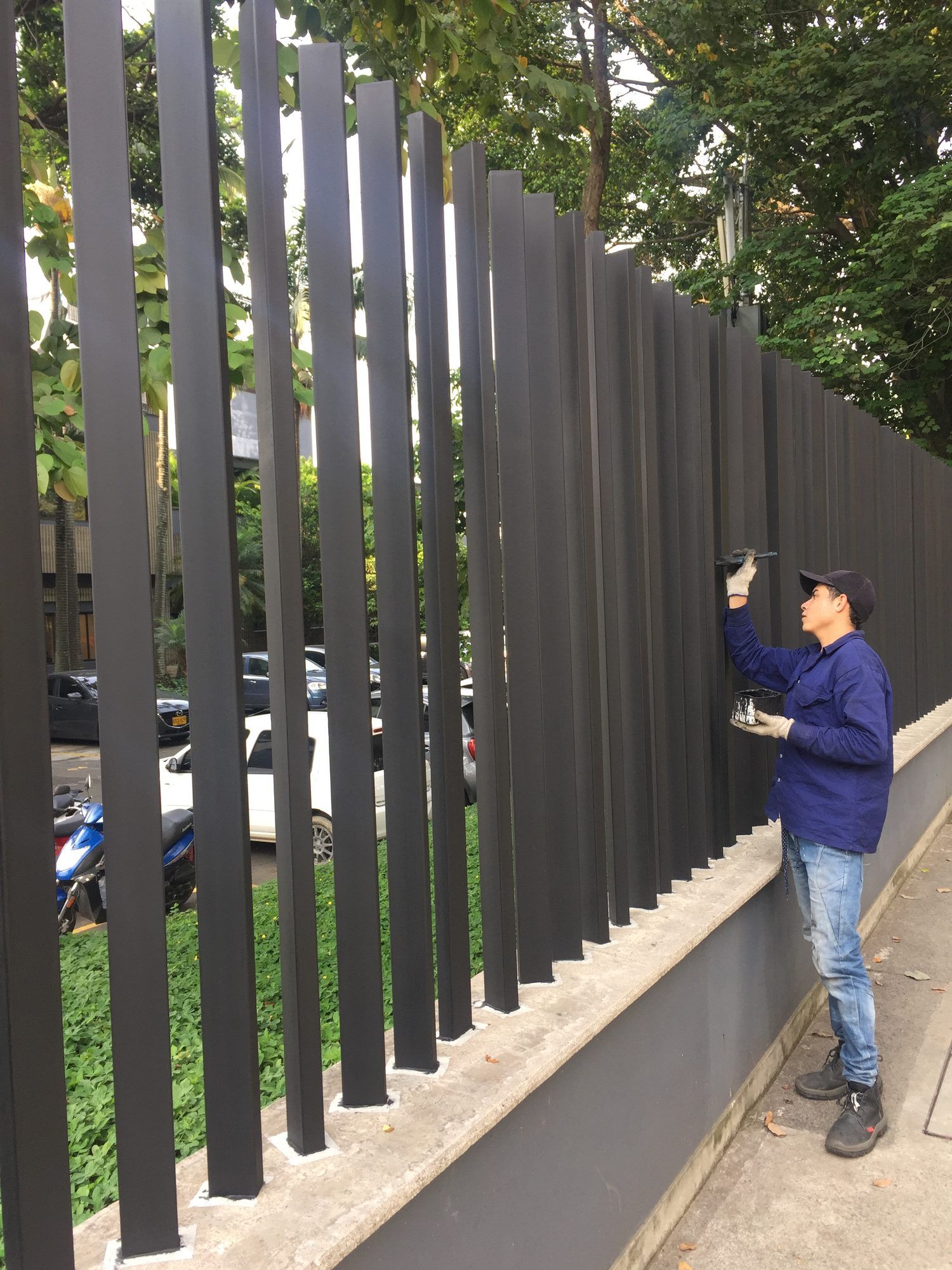 Operario retocando con pincel el acabado grafito de las platinas, en obra
